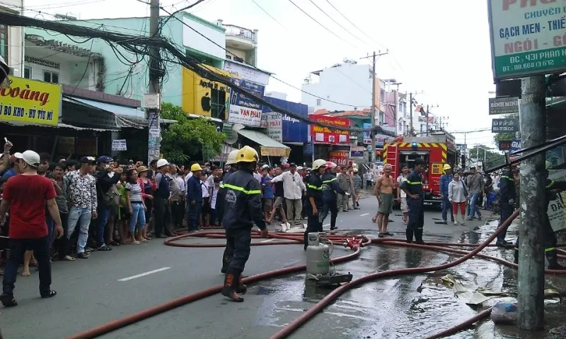 Một bình ga được đưa ra ngoài; rất đông người dân hiếu kỳ theo dõi. 